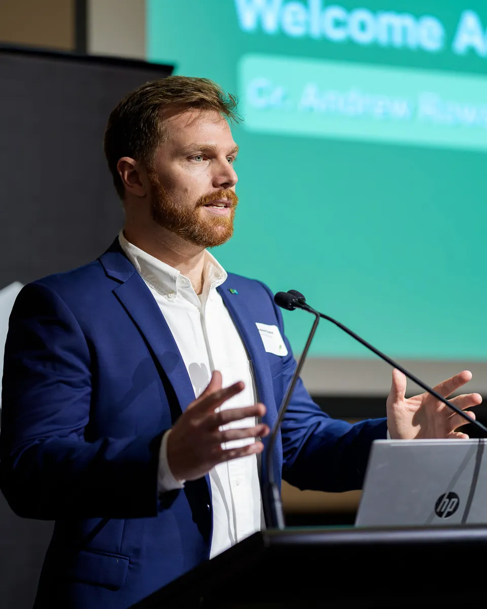 Andrew speaking at a lectern, giving a welcome address