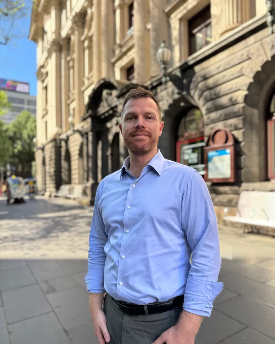 Andrew standing on a city street in front of a historic building