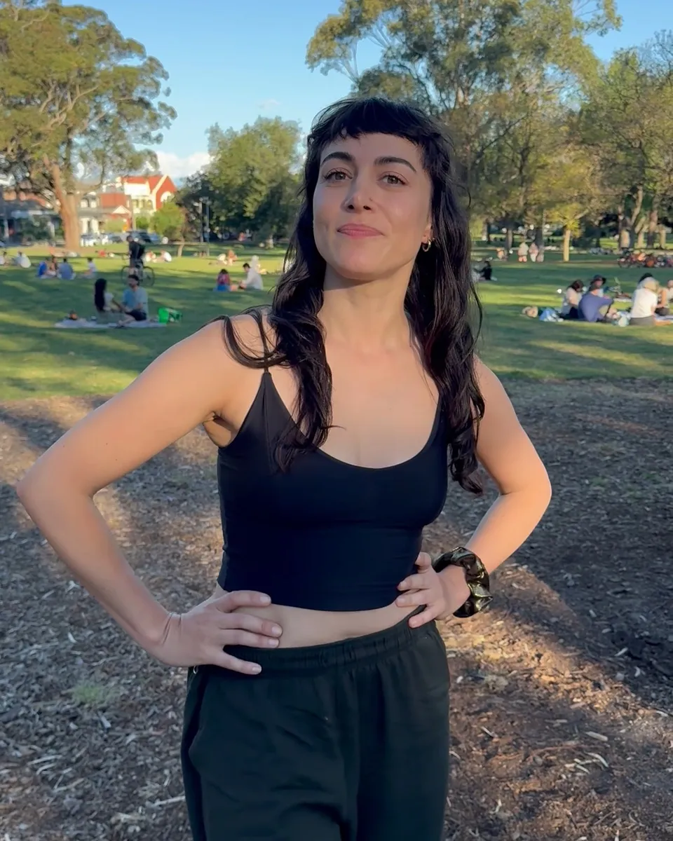 Sahar standing in a sunny park with her hands on her hips